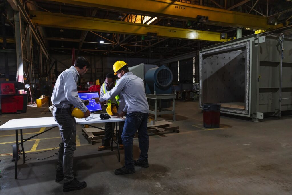 Workers in factory using technology, discuss diagram